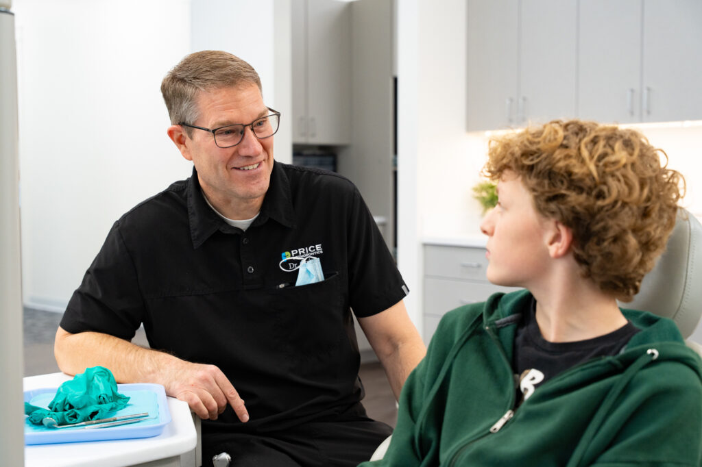 Dr. Cory Price consulting with a patient about braces and Invisalign options in Roy, Utah.